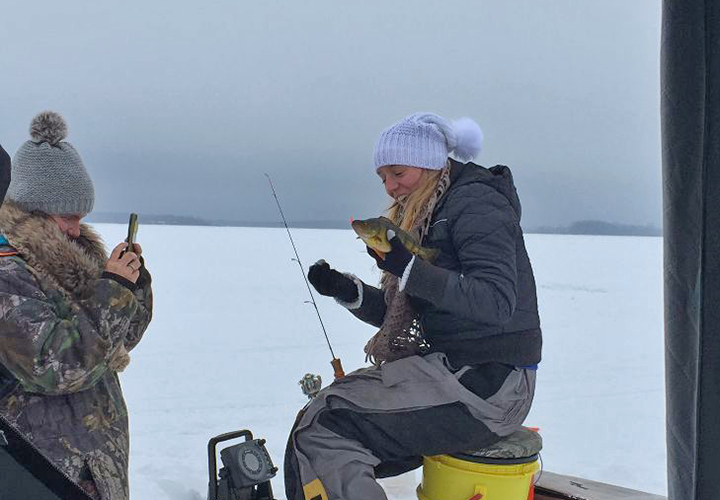 image of girls ice fishing outsside of shelter