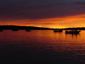 image of boats on the water at sunset