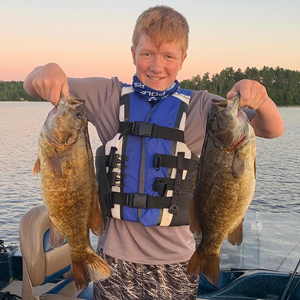 image of young man with 2 nice smallmouth bass