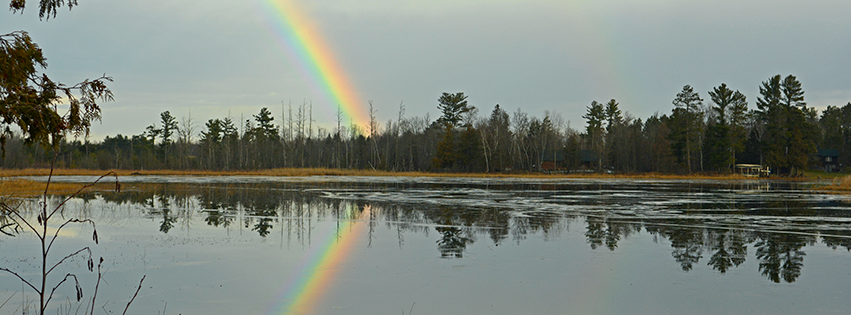 image of rainbow over island lake 