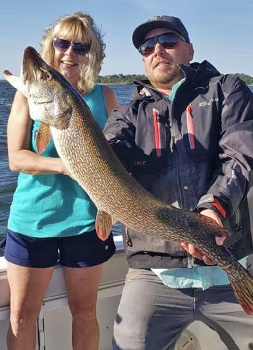 image of big northern pike caught by woman on lake of the woods
