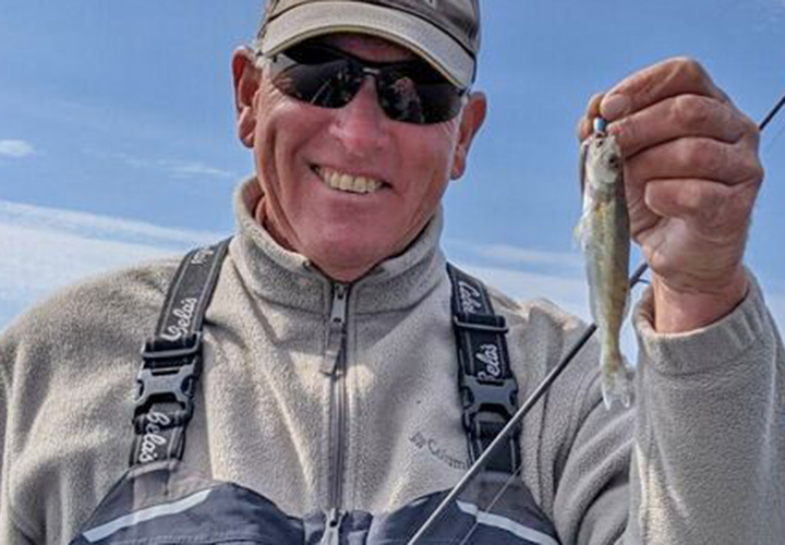 image of jeff sundin holding fingerling walleye from 2021 year class