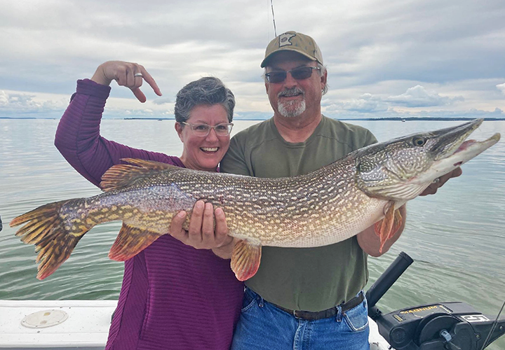 image of woman with huge northern pike caught on Lake of the Woods charter boat