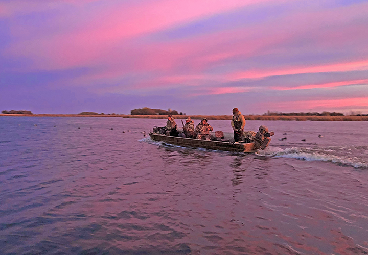 image of duck hunters in boat headed for their hunting blind