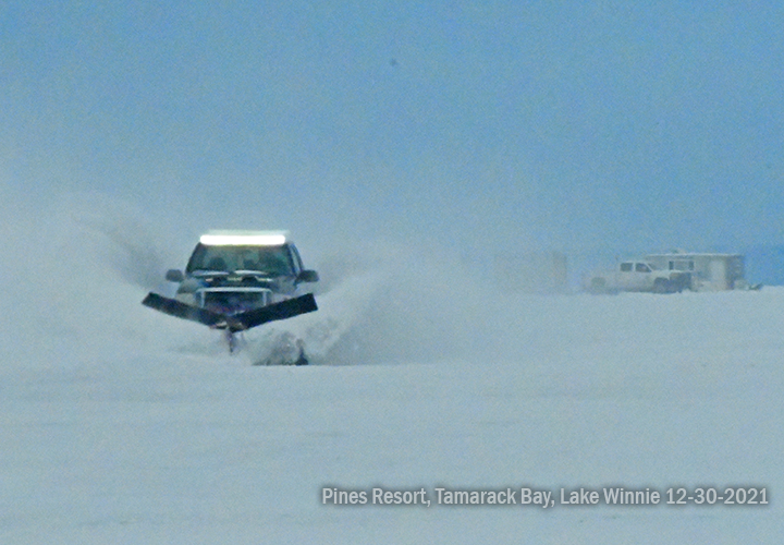 image of pickup truck plowing snow on Lake Winnie