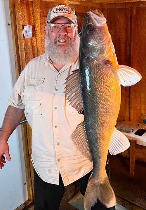 image of walleye fisherman holding giant fish he caught on lake of the woods