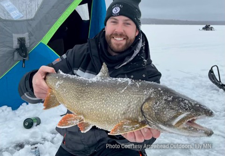 image of ice fisherman holding big trout caught in the Ely MN area