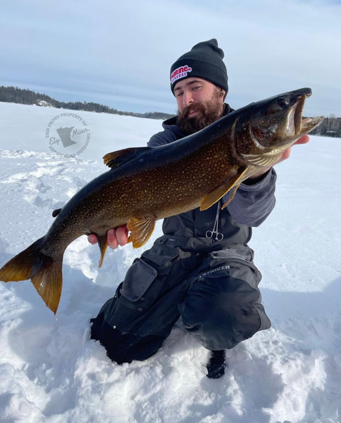 image of ice fisherman holding big lake trout