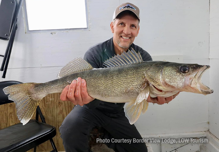 image of ice fisherman holding giant walleye