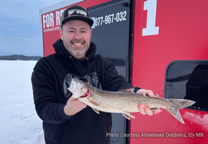 image of ice fisherman holding trout caught in the Ely MN Area