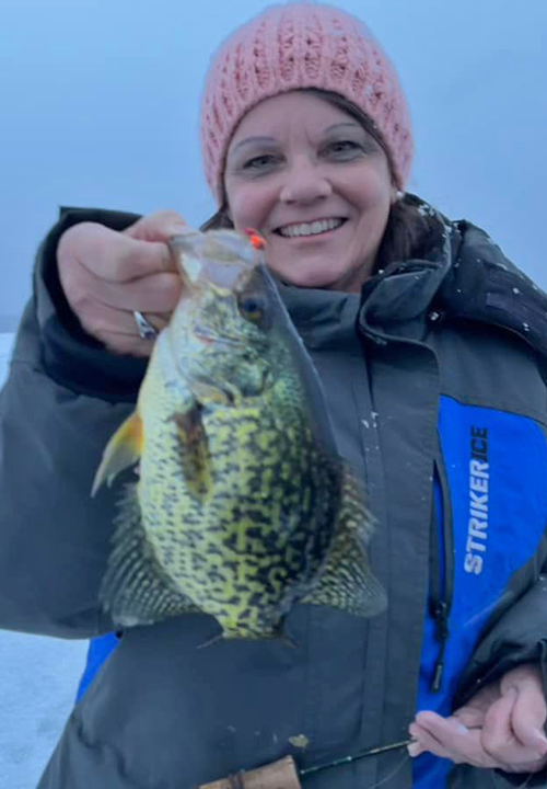 image of the Hippie Chick holding big crappie caught ice fishing near grand rapids