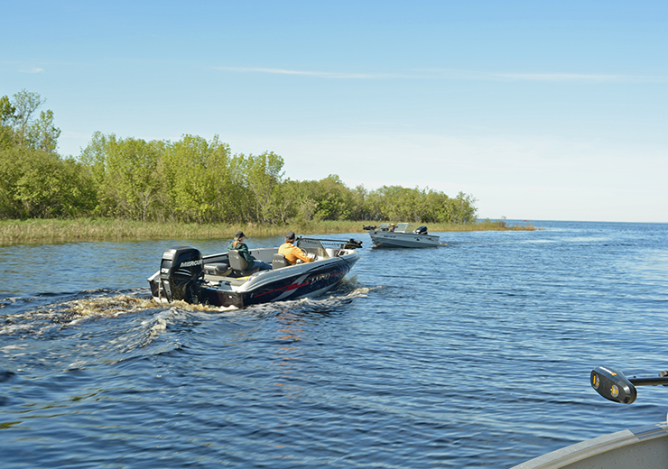 image of boats heading out through the Tamarack River onto Upper Red Lake