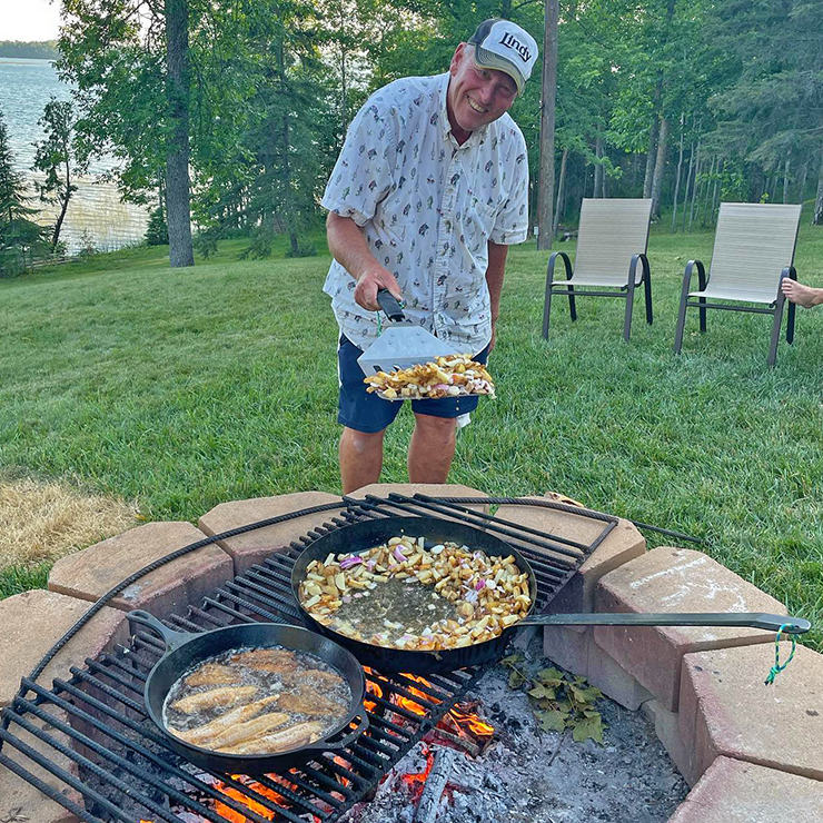 image of fishing guide Jeff Sundin cooking shore dinner for large crew of people