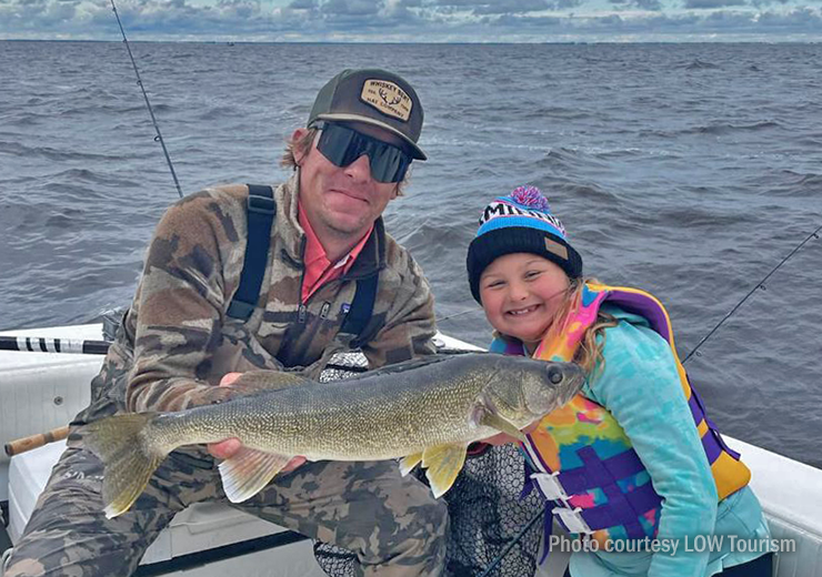 image of charter captain and young girl showing a big walleye caught on aLake of the Woods