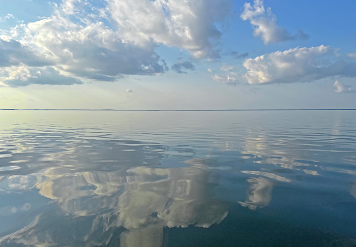 image of mirror glass smooth water with refected clouds on Lake Winnibigoshish