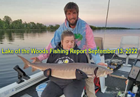 image on young woman holding big sturgeon caught on the rainy river