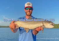 image of fisherman holding big lake trout caught near Ely Minnesota