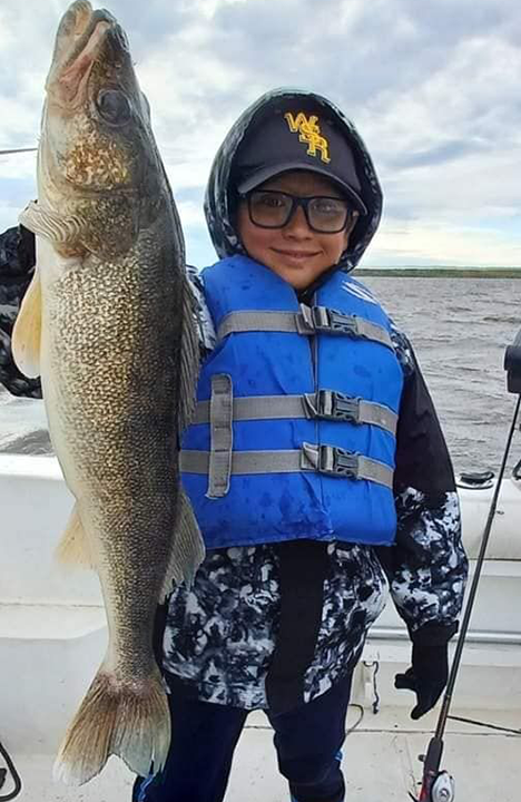 image of young boy holding monster walleye caught on Lake of the Woods