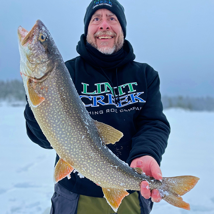 image of ice fisherman holding big lake trout