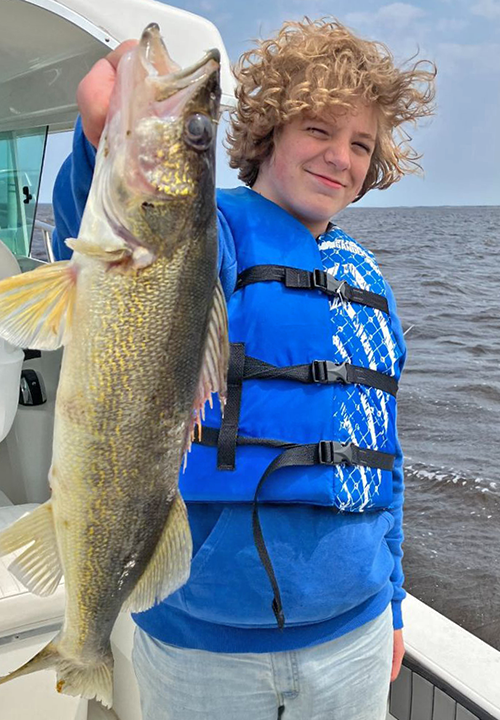 image of young angler holding huge walleye caught on lake of the woods