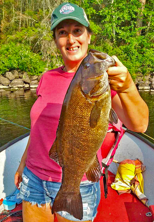 image of woman holding a big smallmouth bass