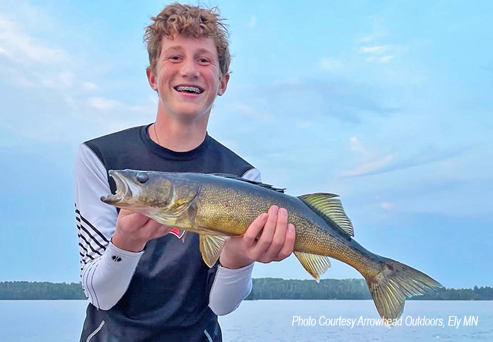 image of young man holding nice walleye caught near Ely Minnesota