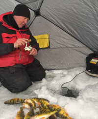 image of ice fisherman reeling up perch