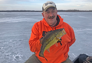 Image of Rick Hastings holding nice bass caught while ice fishing