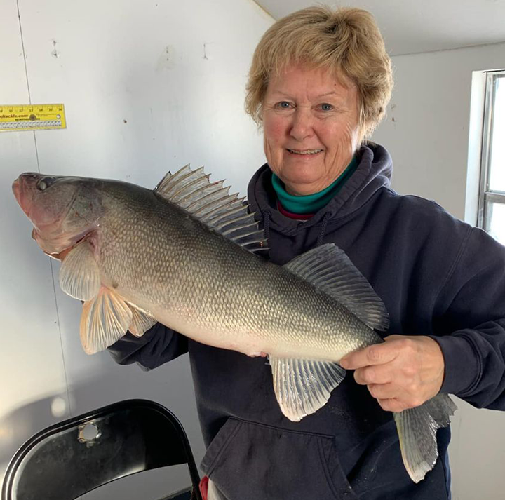 image of lady holding big walleye she caught ice fishing on Lake of the Woods