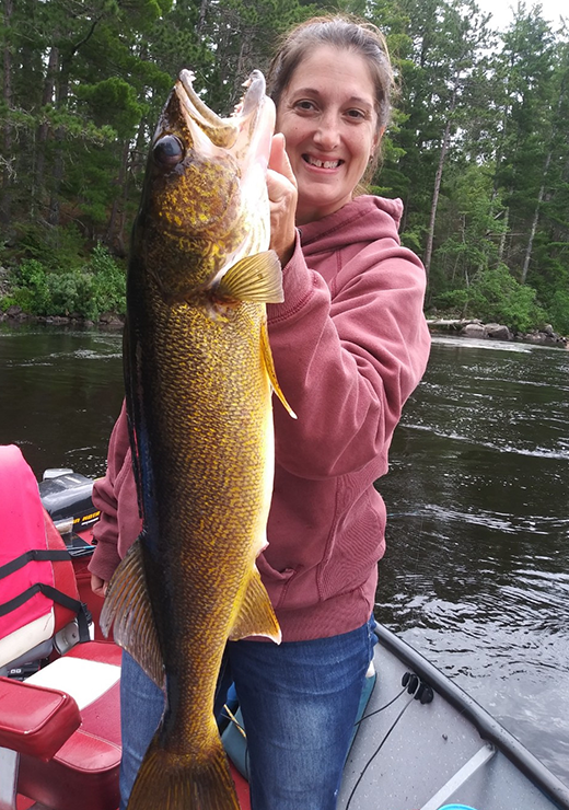 image of woman with gigantic walleye caught near Ely MN