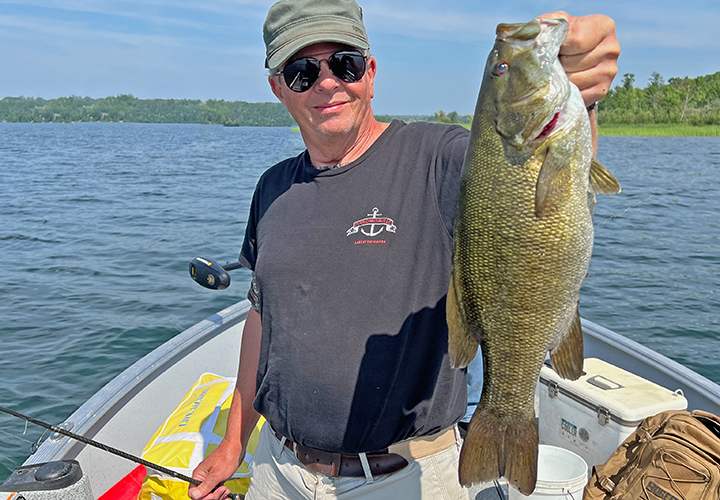 image of Mark holding a big smallmouth bass caught on a fishing charter with Jeff Sundin