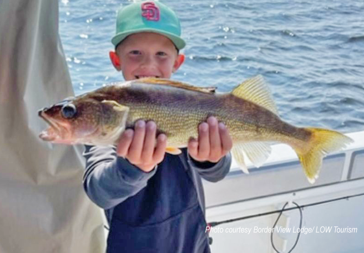image of youngster on charter boat showing off his big walleye