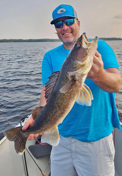 image of man holding big walleye caught in the Ely MN region