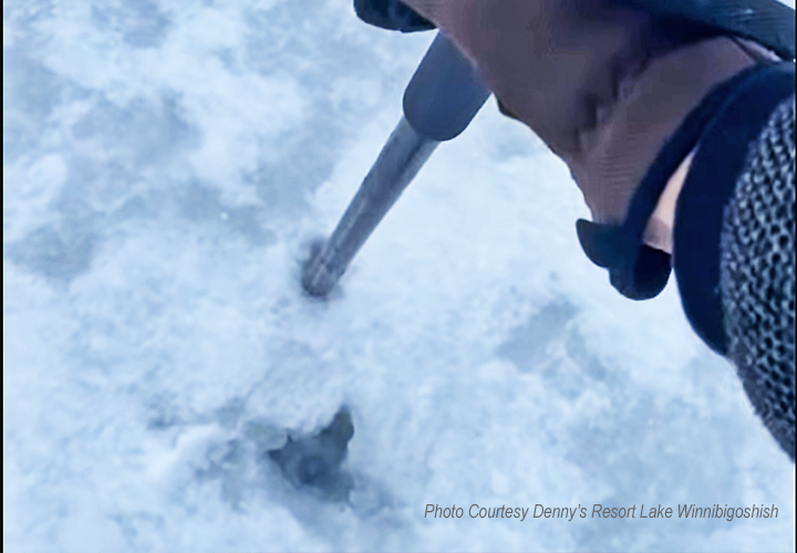 image of ice angler checking conditions on lake Winnie