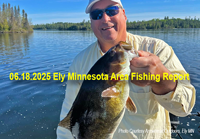 image of fisherman holding huge smallmouth bass he caught in the Ely Minnesota region