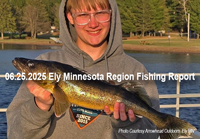 image of young man holding walleye he caught near Ely MN