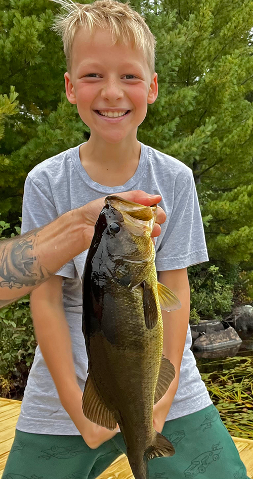 image of young angler with a nice largemouth bass he caught near ely minnesota