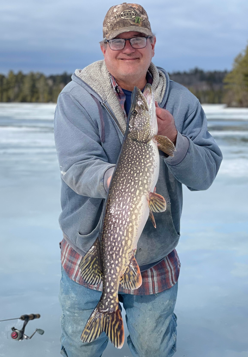 image of ice fisherman holding nice northern pike