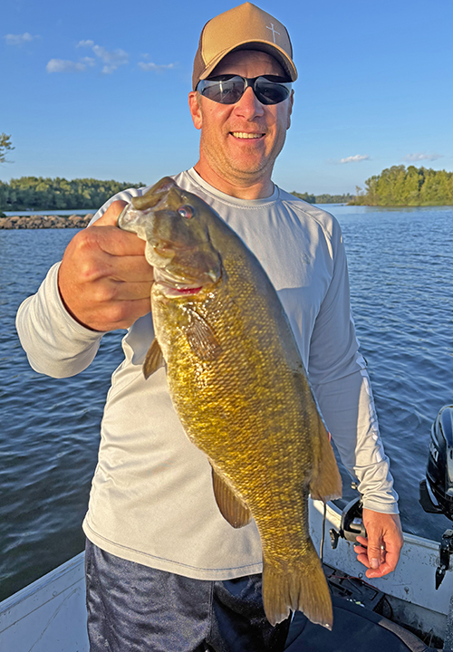Image of man holding a huge smallmouth bass caught in northeast Minnesota near Ely