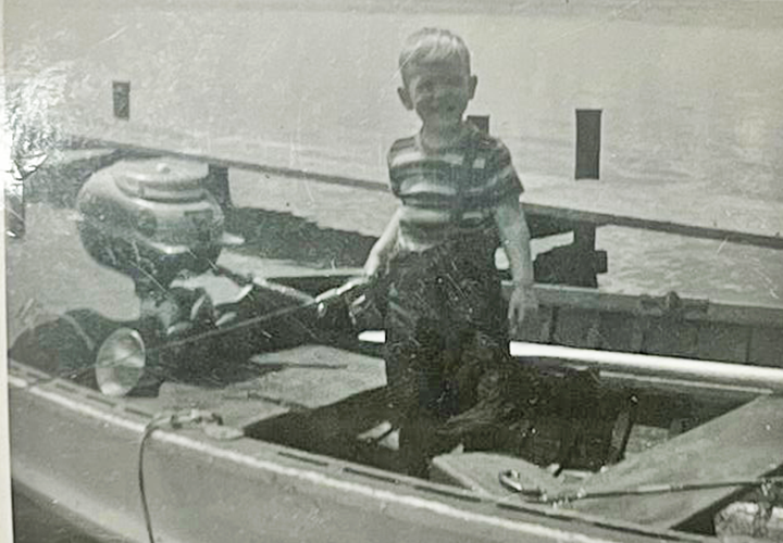image of minnesota hall of fame fishing guide Jeff Sundin from 1960 standing at the tiller of old martin motor