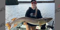 image links to fishing article about a woman who catches a gigantice northern pike