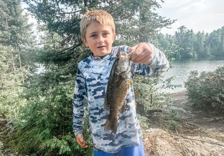 image of youngster holding a nice smallmouth bass caught near Ely Minnesota