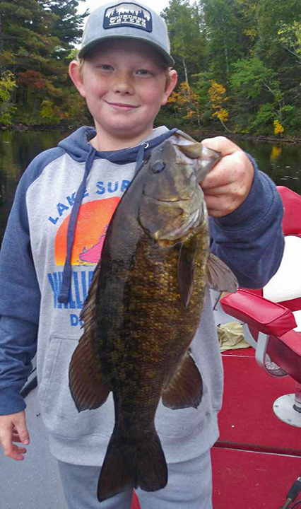 image of young boy holding big smallmouth bass