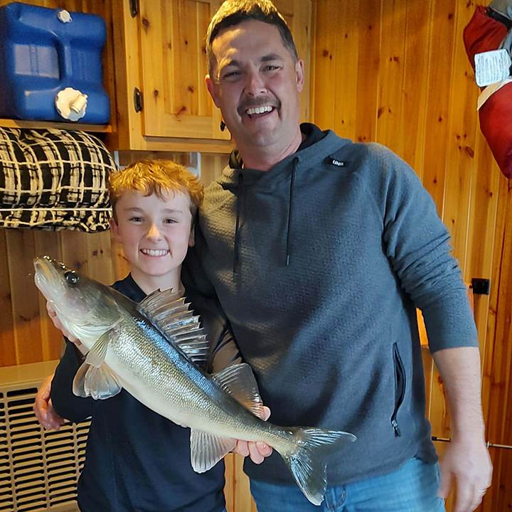 image of father and son ice fishing for walleyes on Shagwa Lake near Ely Minnesota