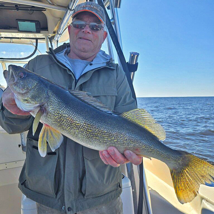 image of walleye fisherman holding large fish he caught while on a charter boat from Arnesen's Rocky Point Resort