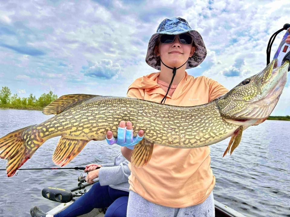 image of youngster holding a huge northern pike caught on Lake of the Woods