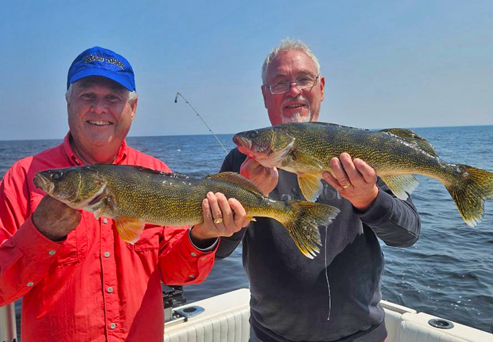 image of 2 walleye anglers holding a pair of walleyes they caught on Lake of the Woods