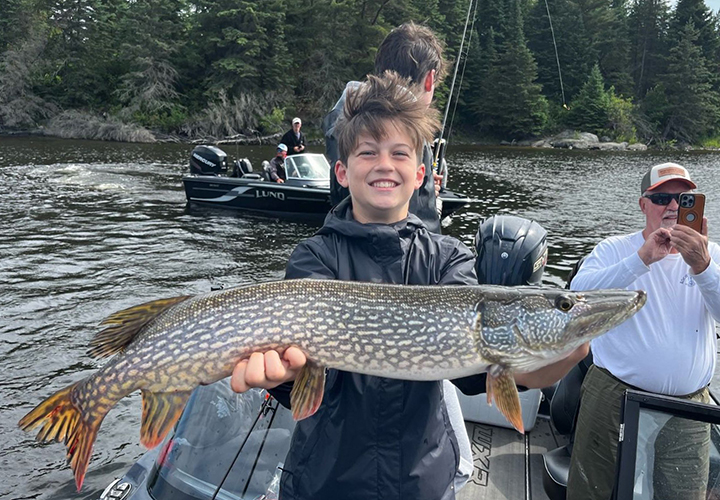 image of young man with huge northern pike caught at the northwest angle